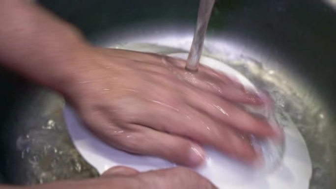 用洗涤剂特写在水槽中清洗盘子