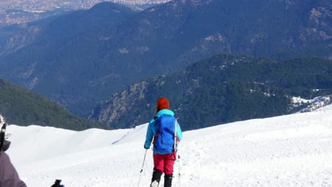 女登山者冬季在雪山峰顶行走