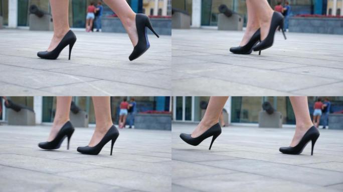 穿着高跟鞋的年轻女商人的脚在城市街道上。穿着黑色鞋子的苗条女性腿穿着高跟鞋走在城市上。女孩踏上工作岗