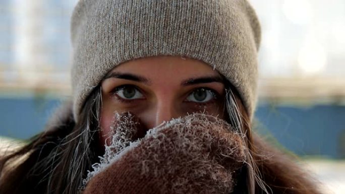 冬季城市景观中年轻幸福的女人的慢动作肖像。