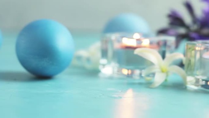 蓝色复活节彩蛋，蜡烛和白色风信子在蓝色混凝土桌子表面背景，复制空间为您文本。节日背景。复活节贺卡快乐