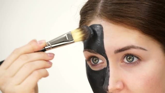 女人在脸上涂黑色碳面膜