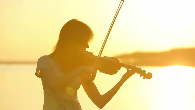 女小提琴手在日落时拉小提琴