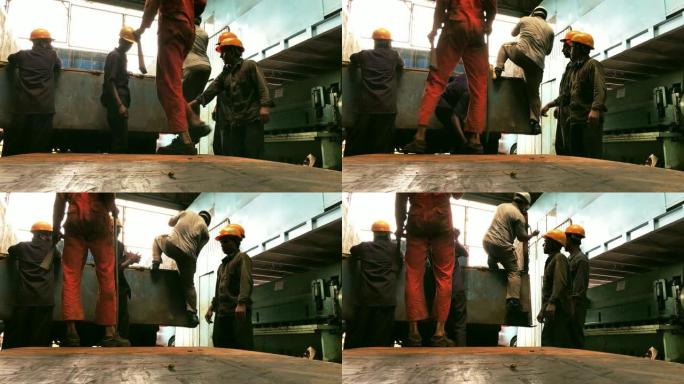 钢铁厂工人从卡车上卸下钢板