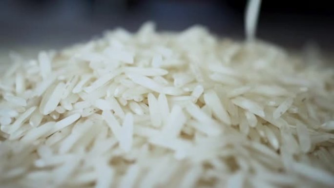 未煮熟的白米在慢动作中掉落成堆的宏观特写