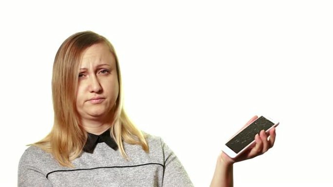 坏掉的小工具的概念。失意的女人在智能手机破碎的屏幕上展示她的手。