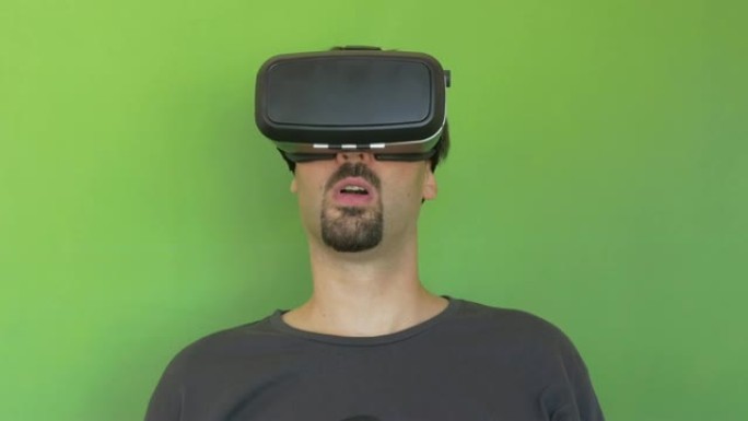 男人把他的VR谷歌在绿屏上慢慢看