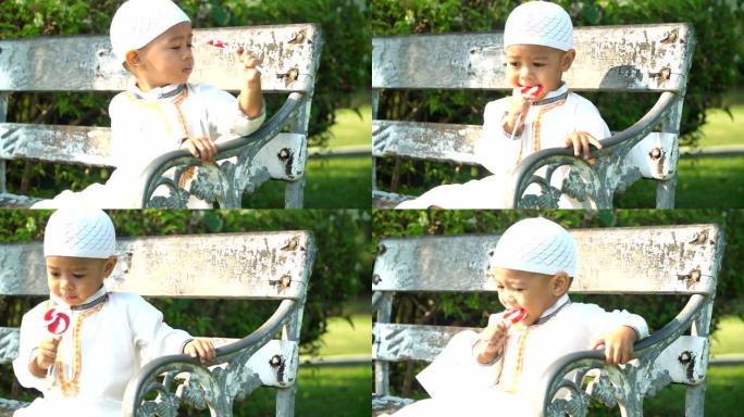 特写: 穆斯林儿子早上在公园的长凳上喜欢糖果