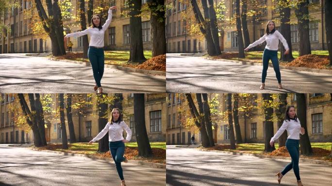 镜头高加索美女独自在公共场所跳舞，快乐和灵感，城市风光，阳光照耀和大学背后