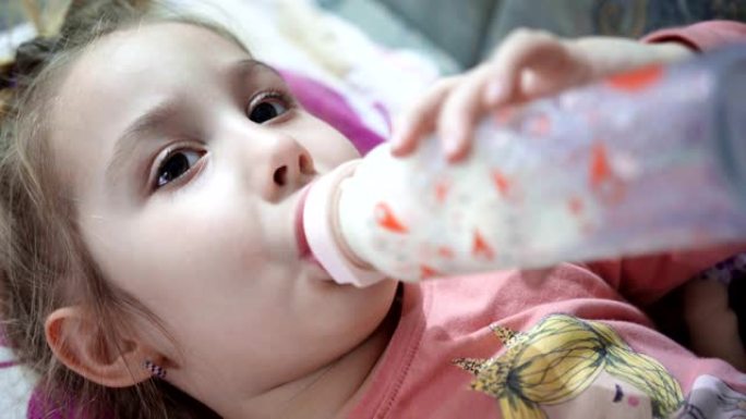 大女孩喝奶瓶里的牛奶