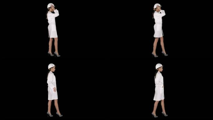 穿着白色长袍的女人在走路时戴上安全帽，阿尔法频道