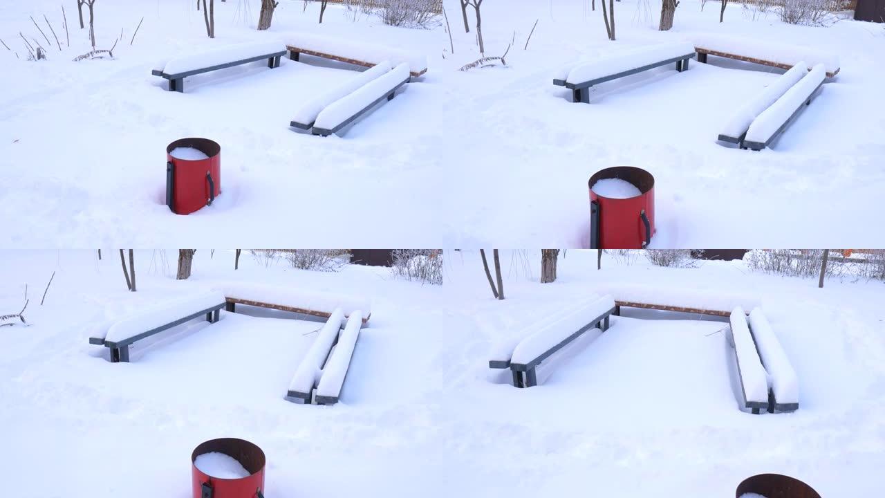有雪的垃圾。雪地里的长凳。下雪的冬天。