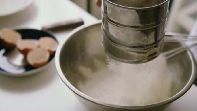 女人在碗里筛面粉