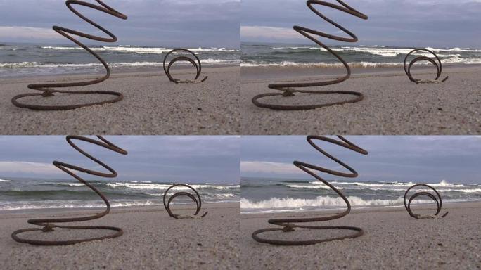 海洋沙滩上的老生锈金属弹簧和海浪