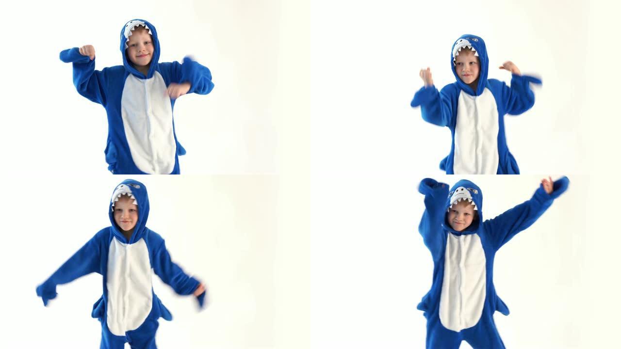 穿着睡衣kigurumi，蓝鲨服装的白色背景上快乐的小男孩跳舞
