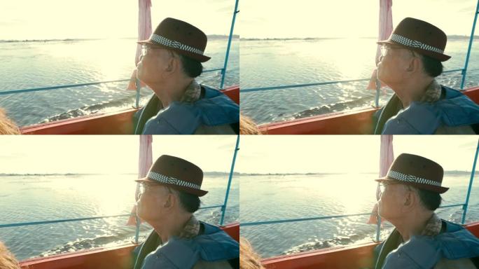 亚洲高级男性的快乐时光，在船上的湖边欣赏日出的景色，慢动作