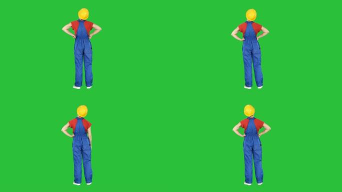施工头盔中的女工程师双手叉腰站在绿色屏幕上，色键