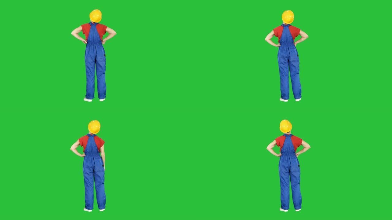 施工头盔中的女工程师双手叉腰站在绿色屏幕上，色键
