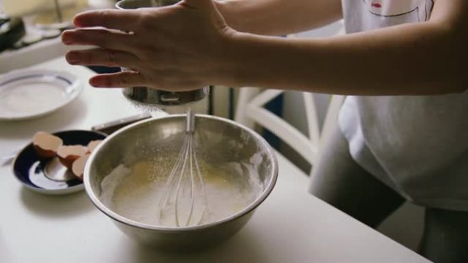 女人在碗里筛面粉