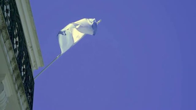 一面以蓝天为背景的阿根廷国旗在阳台上飘扬