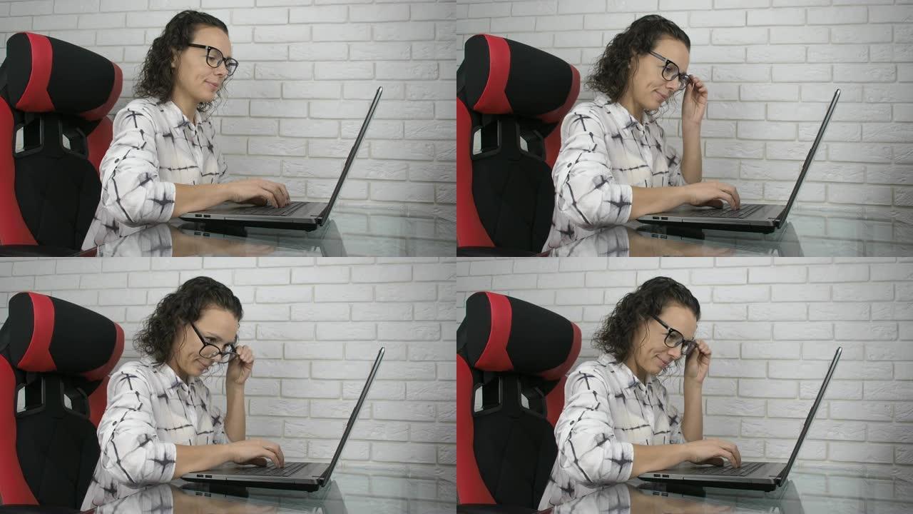 女人在电脑上偷看眼镜。