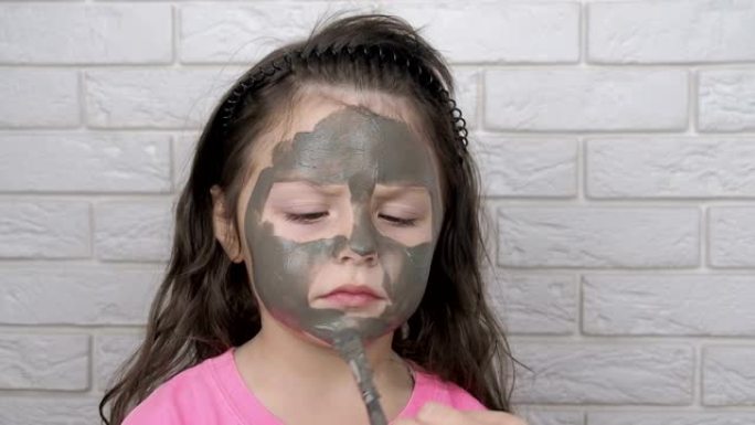 脸上戴着粘土面具的孩子。