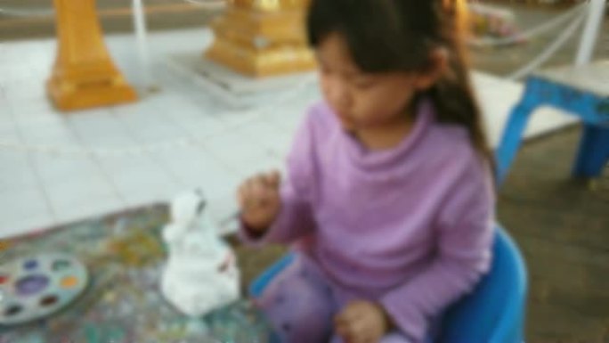 女孩在石膏雕像上画颜色
