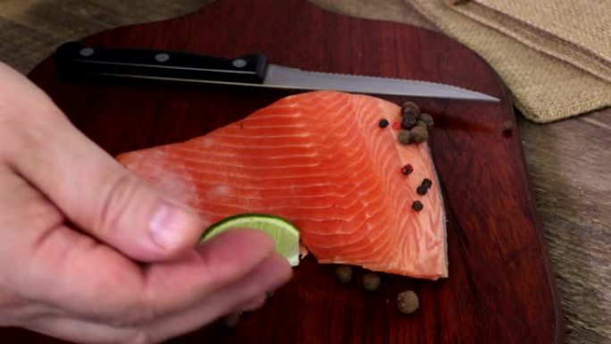 男子将纸放在木切刀上的鲑鱼片周围