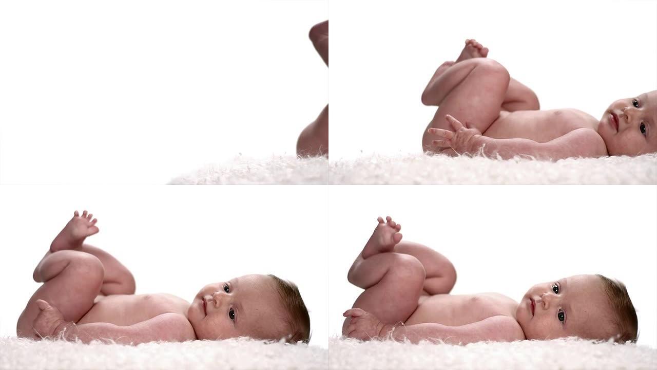 相机缓慢平移时，婴儿躺在柔软的白色毯子上