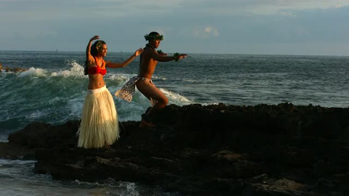 波利尼西亚舞者在海浪撞击岩石时表演