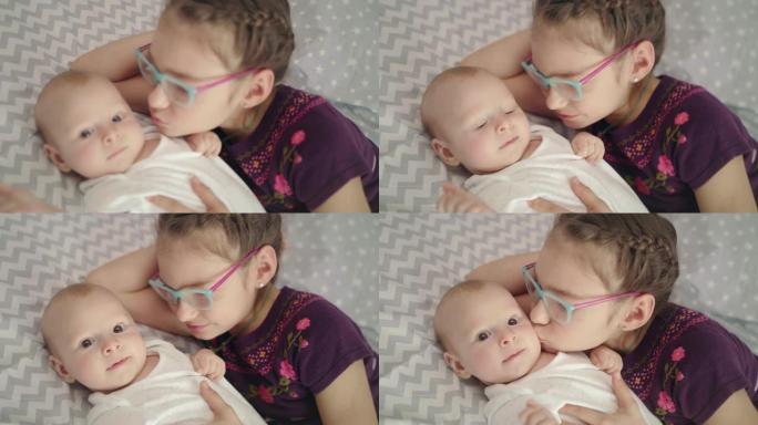 女孩亲吻宝贝。姐姐亲吻新生哥哥。姐妹爱情概念