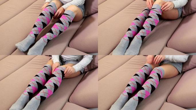 沙发上的女人整理过膝袜子