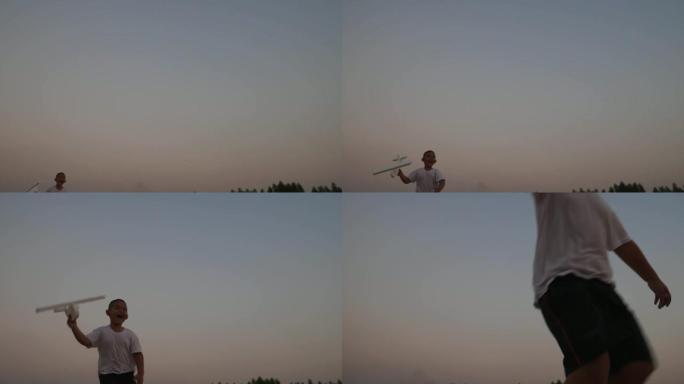 男孩在日落时在田野上奔跑的手中玩木制飞机