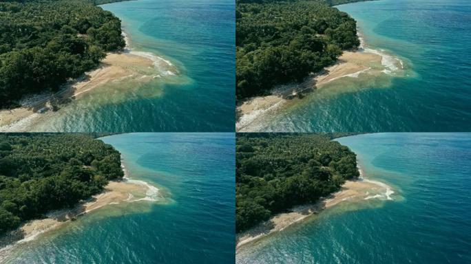 一个偏远的南太平洋岛屿的空中无人机图像，拥有沙滩海岸和美丽的海洋海景和郁郁葱葱的热带雨林丛林