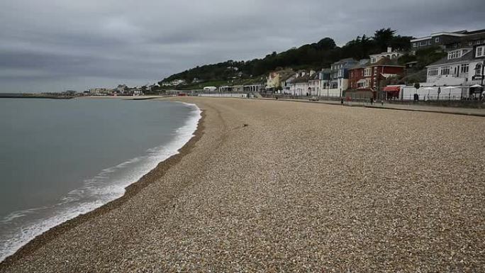 英国多塞特的莱姆里吉斯海滩，海浪拍打着海岸