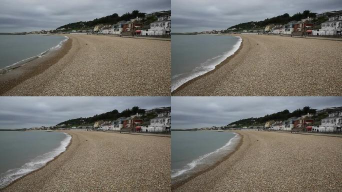 英国多塞特的莱姆里吉斯海滩，海浪拍打着海岸