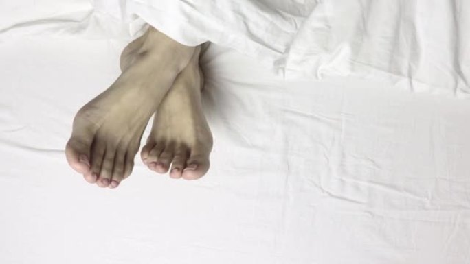 女人腿脚躺在床上，俯视图，早上醒来放松