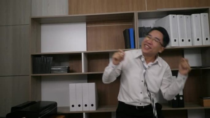 快乐成功的商人在办公室跳舞