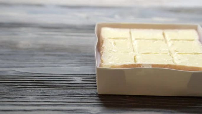 面包将黄油涂在木桌上，早餐食品与奶酪奶油美味可口，运动。
