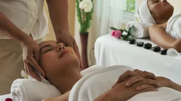亚洲美女正在放松与面部和头部按摩水疗沙龙。泰式保健按摩。4k视频慢动作