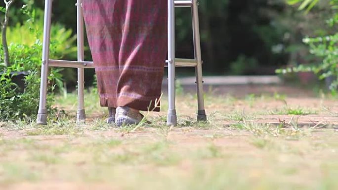 老年妇女在后院使用助行器。