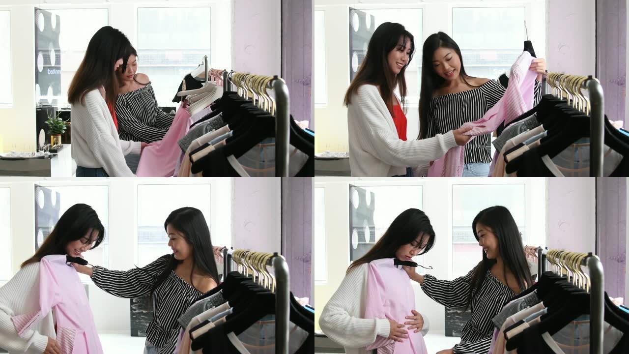 微笑的中国女性在时装店买衣服