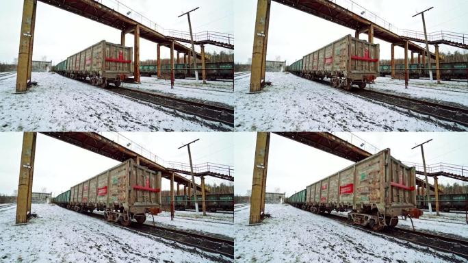 冬天的一天，装有货物的联合集装箱在桥下的火车站在铁轨上移动。