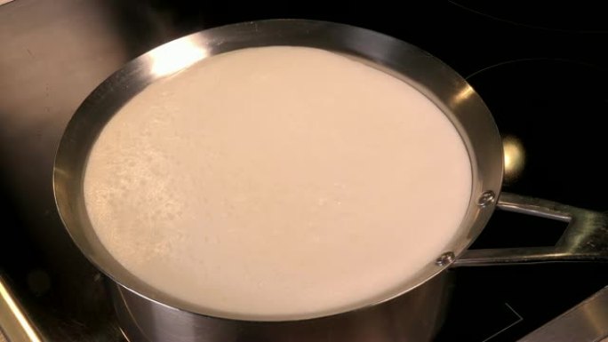 煮天然有机牛奶，将牛奶放在锅中煮沸，即将溢出的牛奶，溢出的牛奶