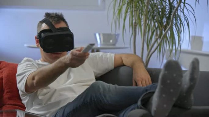 穿着白衬衫的男人在沙发上享受虚拟现实谷歌