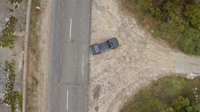 在临街道路上关闭的汽车的空中射击。老式黑色宝马的鸟瞰图在临街道路上关闭