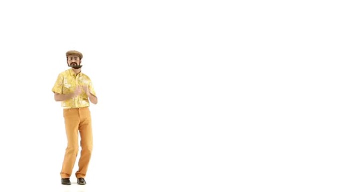 年轻的70多岁的大胡子男人穿衣帽和黄色花卉橙色复古衬衫进入并在103 bpm音乐轨道上跳舞-孤立的白