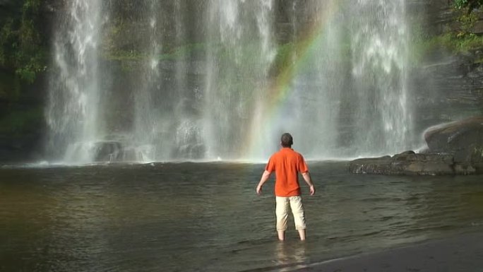 人与彩虹的热带瀑布