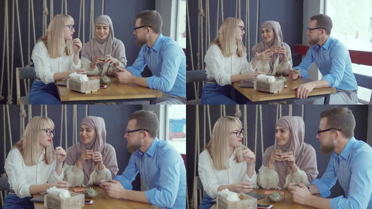 三个高加索人和穆斯林朋友男女在聊天喝茶