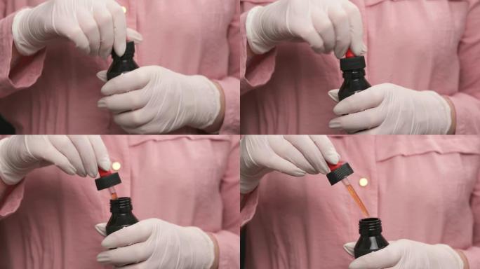 用医用乳胶手套打开瓶子的女性手的特写镜头，用适当的剂量填充移液管。